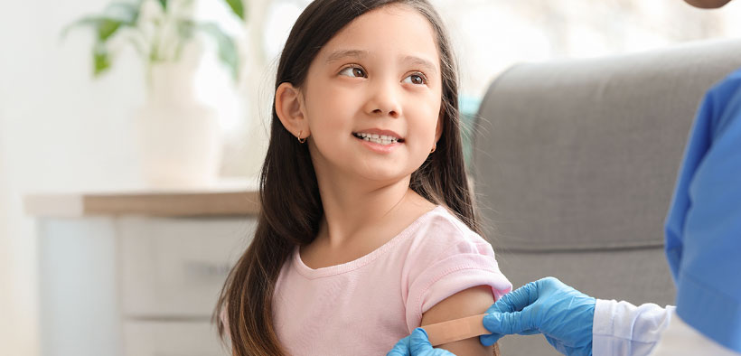 girl getting bandaid placed on arm
